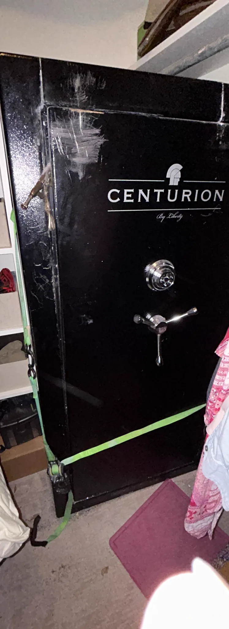 Heavy lifting strap secured around a tall gun safe staged for a move