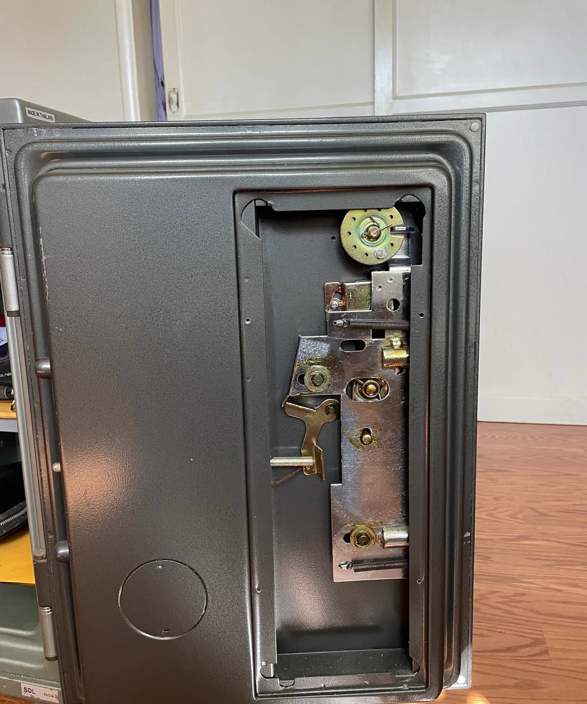 Open safe door showing bolt work and relock mechanism during repair