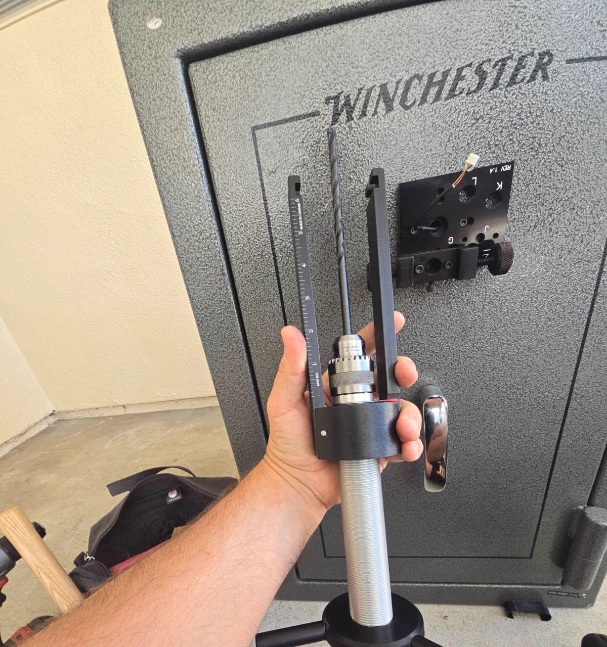 Drill rig clamped to the door of a Winchester gun safe during an opening